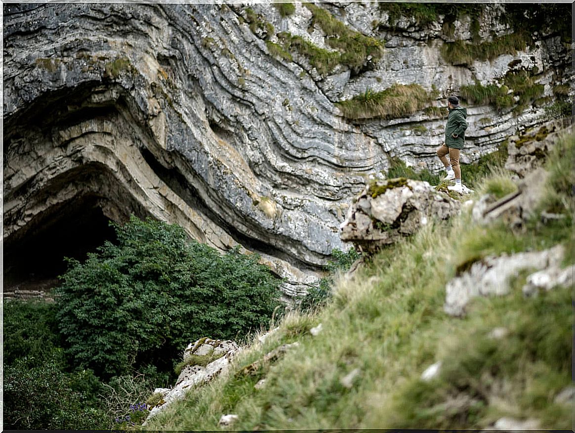 Tourist posing at the entrance of the Arpea cave.