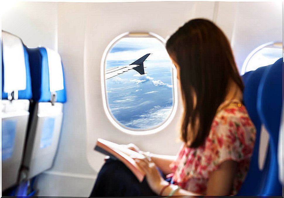 Female passenger reading on an airplane