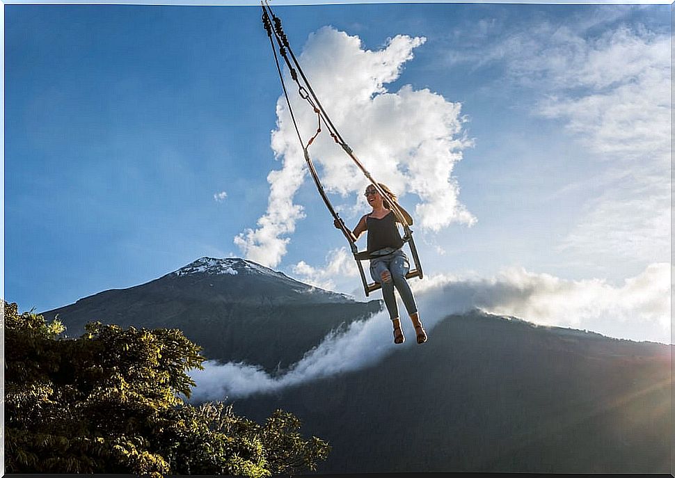 Tungurahua volcano and woman swinging